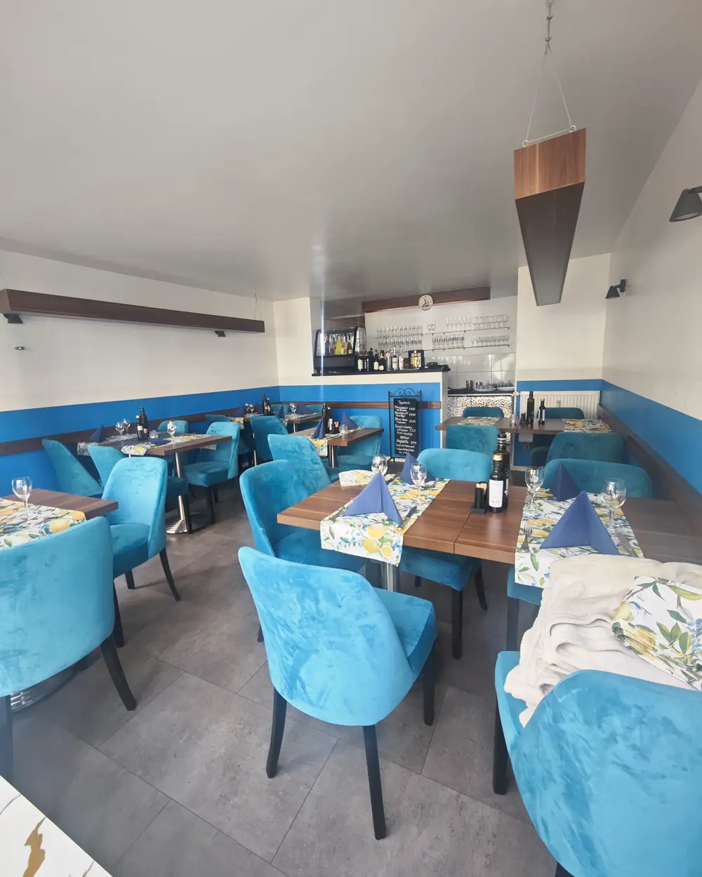 La Pasteria dining room with blue velvet chairs and set tables